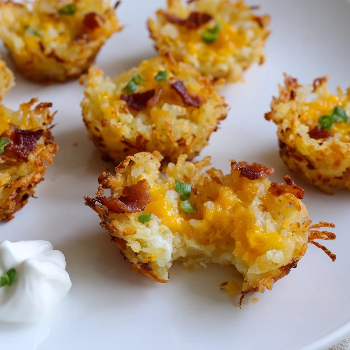 Mini muffin tin of cheesy loaded hashbrown bites with gooey cheese and green onions