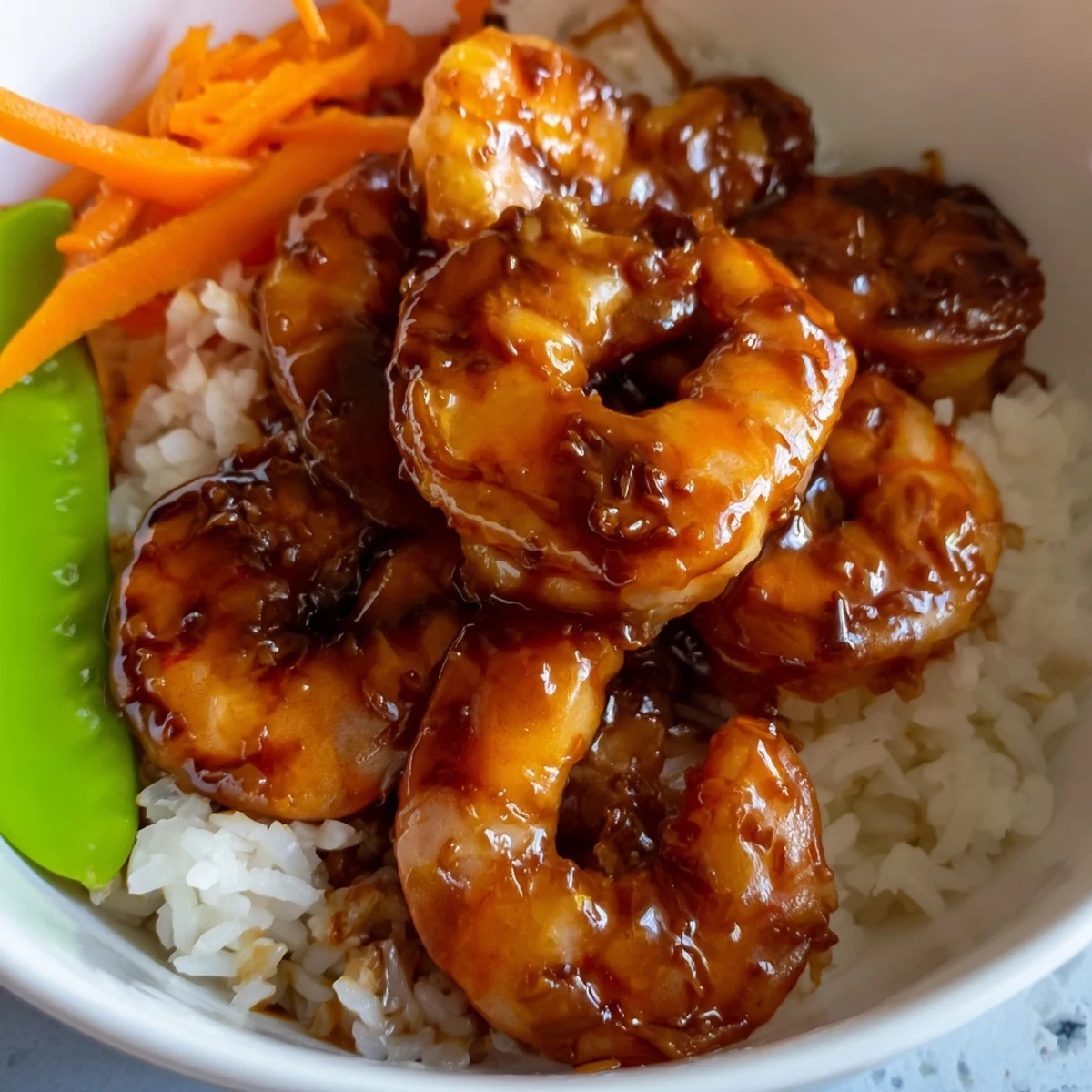 Colorful teriyaki shrimp rice bowls garnished with green onions and nori strips.