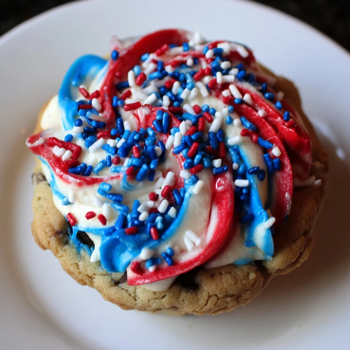 Golden Patriotic Chocolate Chip Cookie Cups topped with red white blue frosting for summer celebrations  