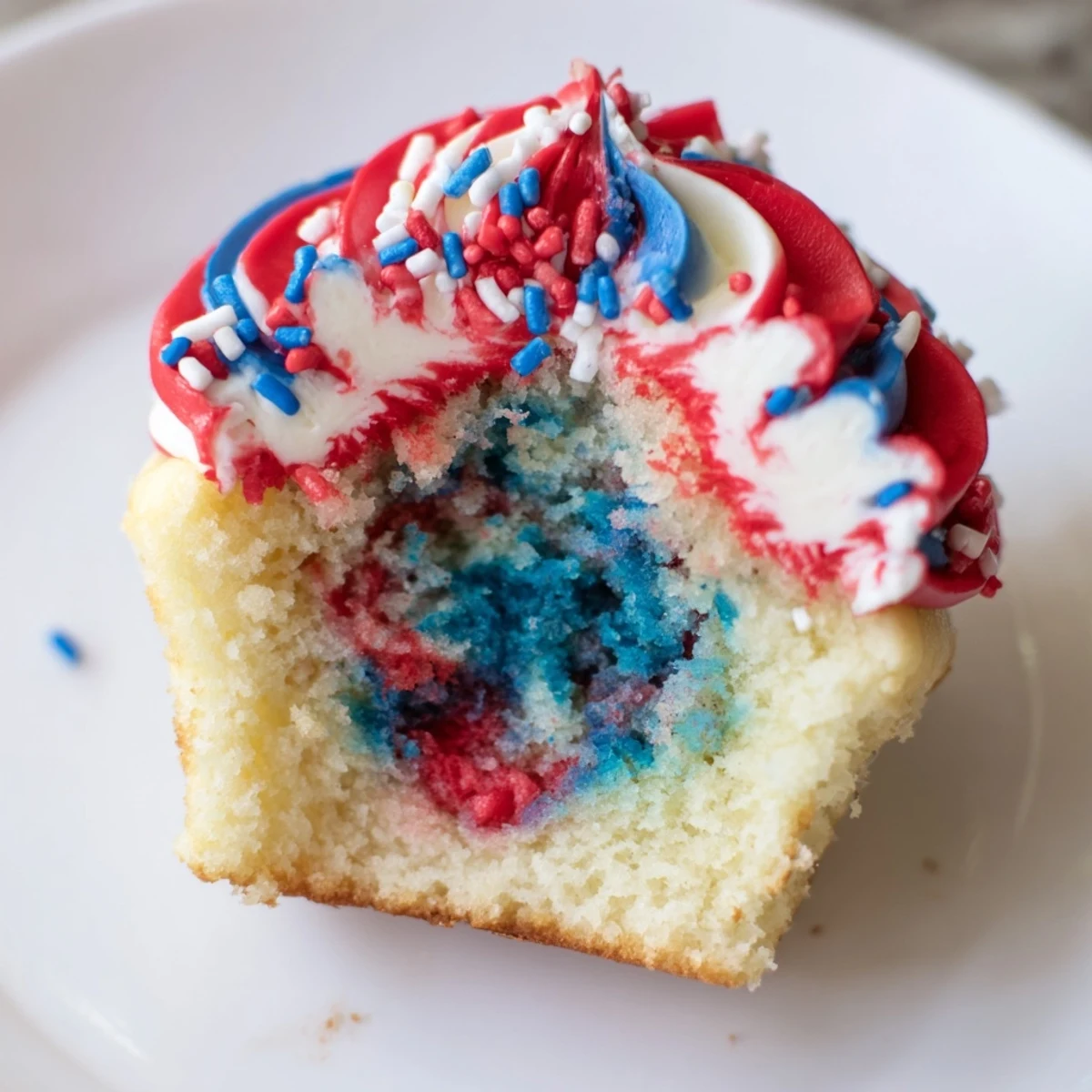 Colorful July tie dye cupcakes with red, white, and blue swirls.  