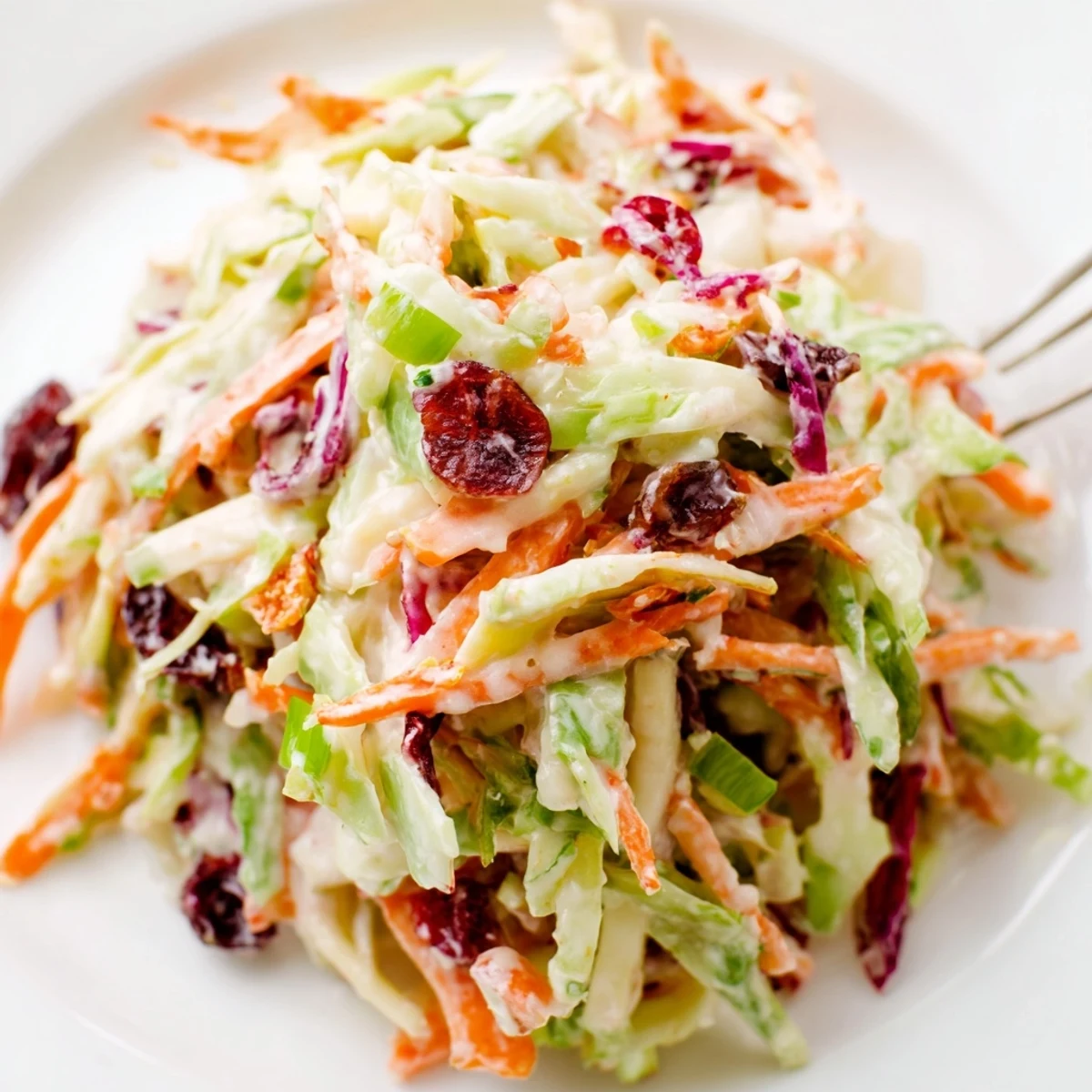 Colorful Cranberry Apple Coleslaw showcasing shredded vegetables, fruit, and dried cranberries for a tangy side.