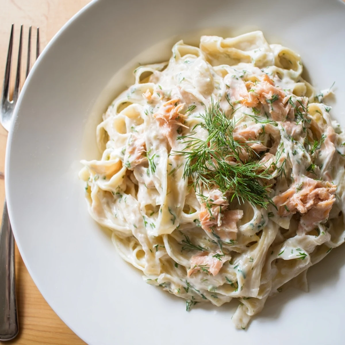 Elegant hot smoked salmon pasta garnished with lemon wedges and black pepper